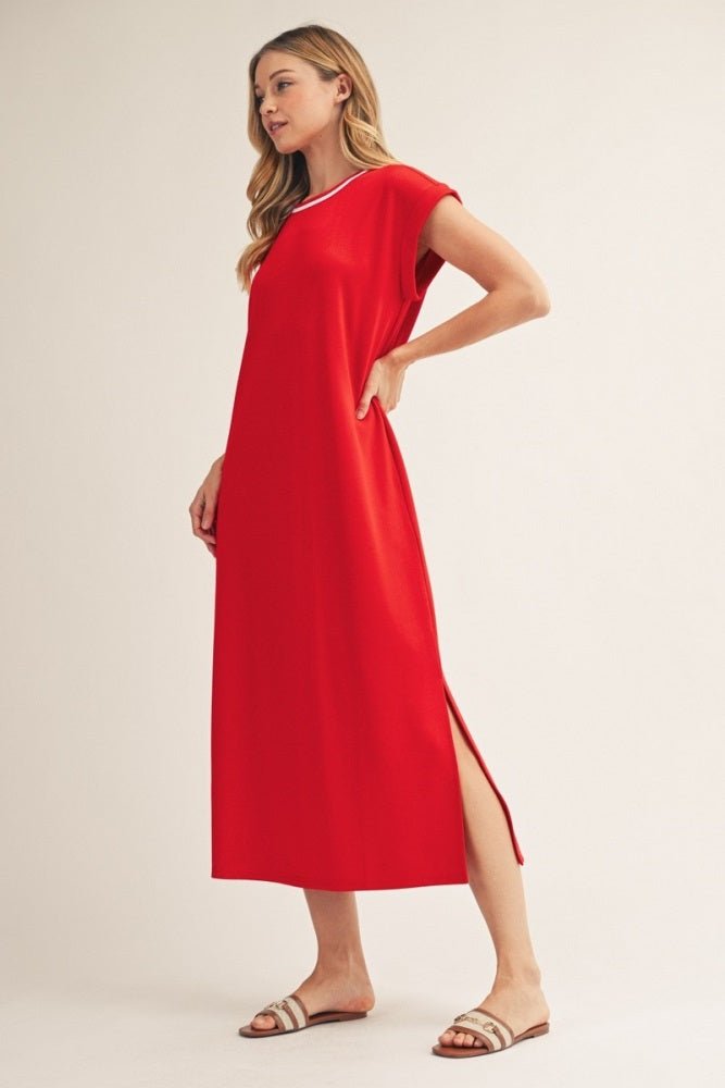 woman wearing a red maxi dress with short sleeves and side slits, standing in a relaxed pose