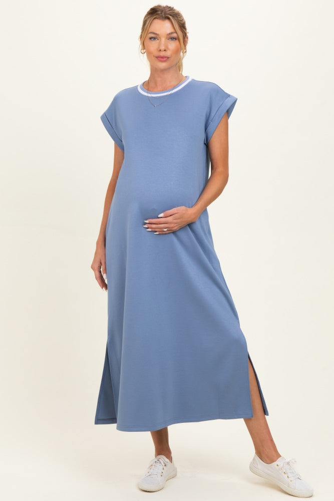 woman wearing a light blue maternity maxi dress with short sleeves and side slits, holding her baby bump