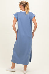 woman wearing a relaxed fit blue maxi maternity dress with short sleeves and side slits, showing her back