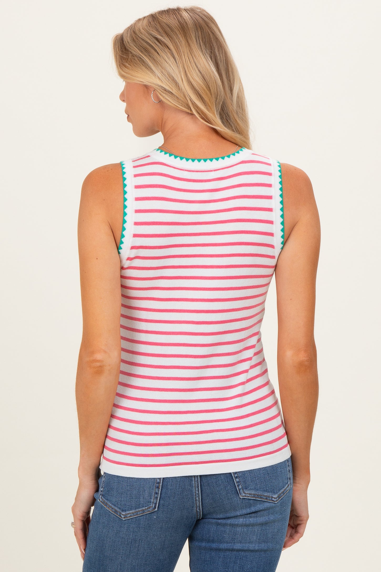 woman wearing a white striped maternity tank top with green and pink accents, viewed from the back