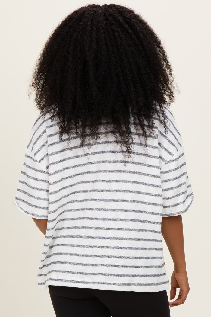 woman wearing a white and gray striped oversized t-shirt, viewed from the back