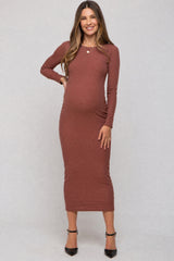 woman wearing a rust long sleeve ribbed maternity dress and showing her baby bump