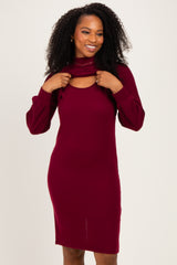 woman wearing a burgundy long sleeve ribbed dress with a cut-out detail at the neckline and gathered sleeves