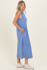 woman wearing a light blue sleeveless maxi dress with pockets and white sneakers