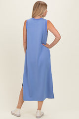woman wearing a sleeveless blue maxi dress with side slits and a relaxed fit, viewed from the back