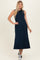 woman wearing a navy blue sleeveless maxi dress paired with black and white sneakers