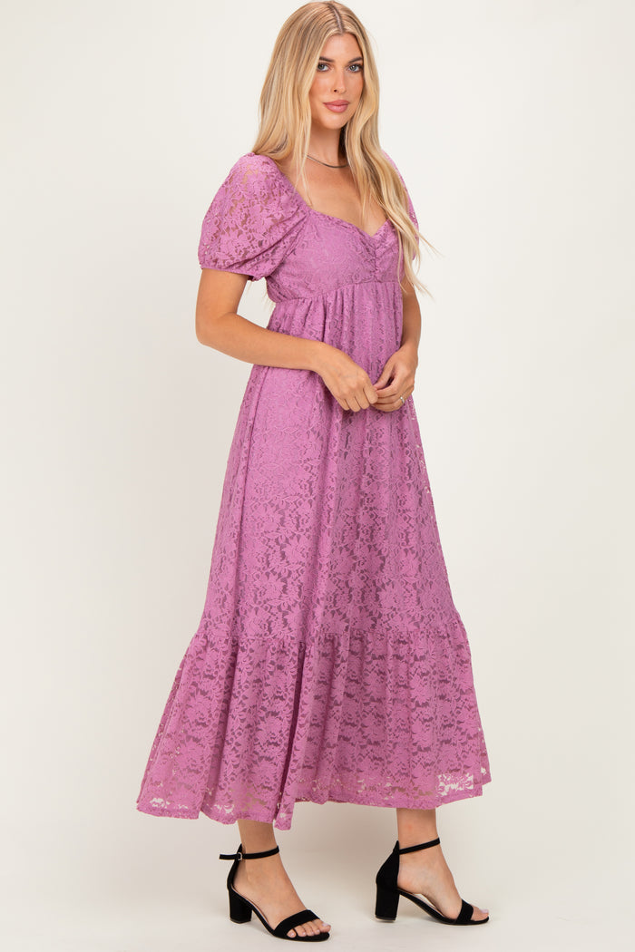 woman wearing a purple lace maxi dress with puff sleeves and a tiered skirt, standing in a relaxed pose