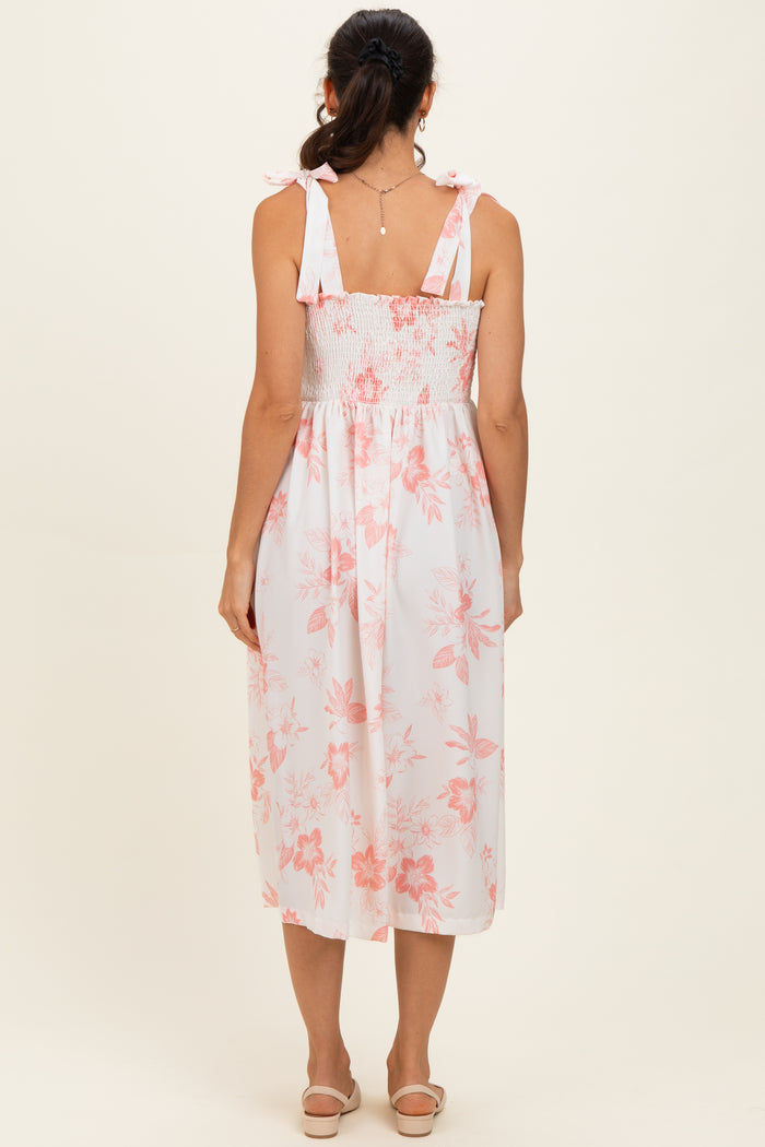 woman wearing a white floral midi dress with a smocked back and ruffled shoulder straps