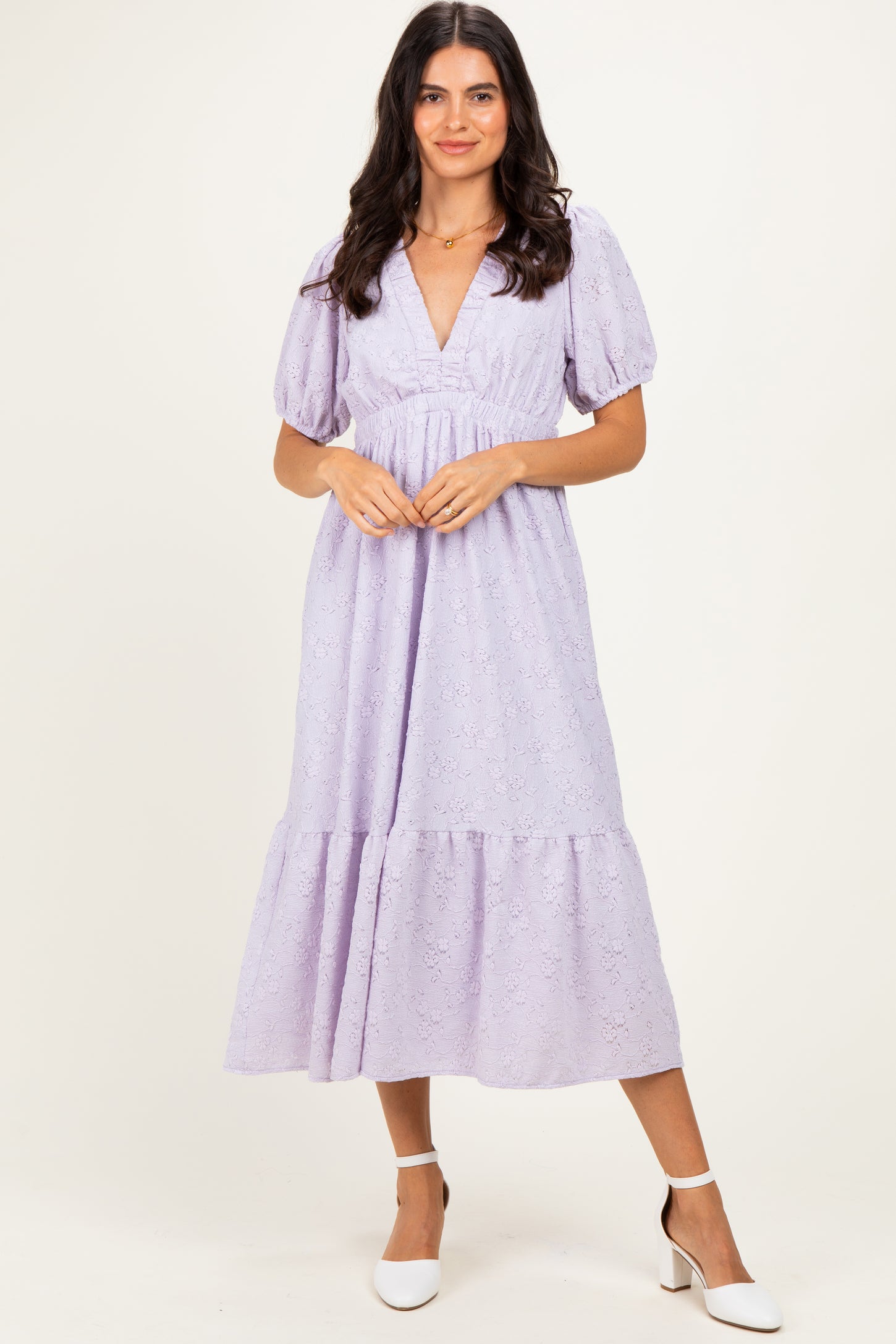 woman wearing a light purple puff sleeve midi dress with a deep v-neck and lace detailing