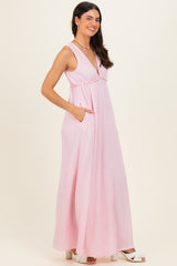 woman wearing a pink sleeveless maxi dress with a v-neck and pockets