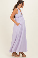 woman wearing a lavender long maxi maternity dress with pockets and a deep V-neck, showing her baby bump