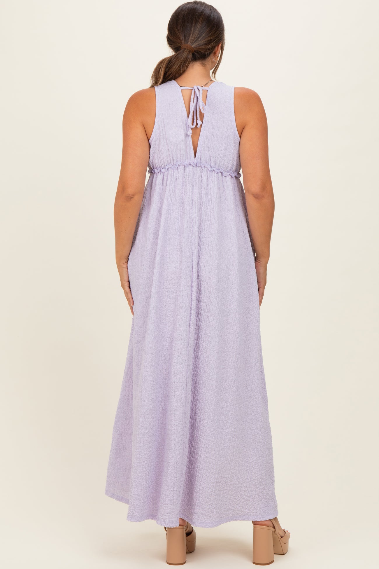 woman wearing a lavender maternity maxi dress with a back tie detail and a flowing fit
