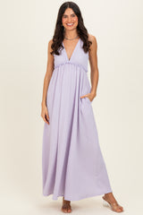 woman wearing a lavender maxi dress with a v-neckline, ruffled waist, and side pockets
