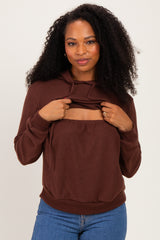woman wearing a brown hooded sweatshirt with a scoop cutout and relaxed fit