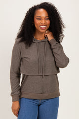 woman wearing a dark gray layered hoodie with a front flap and long sleeves paired with blue jeans