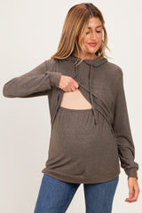 woman wearing a dark brown maternity hoodie with a front opening, revealing her baby bump, paired with blue jeans