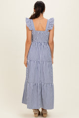 woman wearing a navy and white striped maxi dress with ruffled straps and a smocked back, viewed from the back
