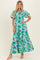 woman wearing a green floral maxi dress with puff sleeves and a smocked bodice