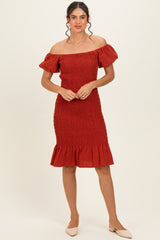 woman wearing a rust off-the-shoulder smocked dress with ruffle hem and short sleeves
