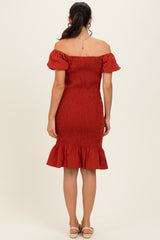 woman wearing a red off-shoulder smocked dress with ruffled hem and short puff sleeves, seen from the back
