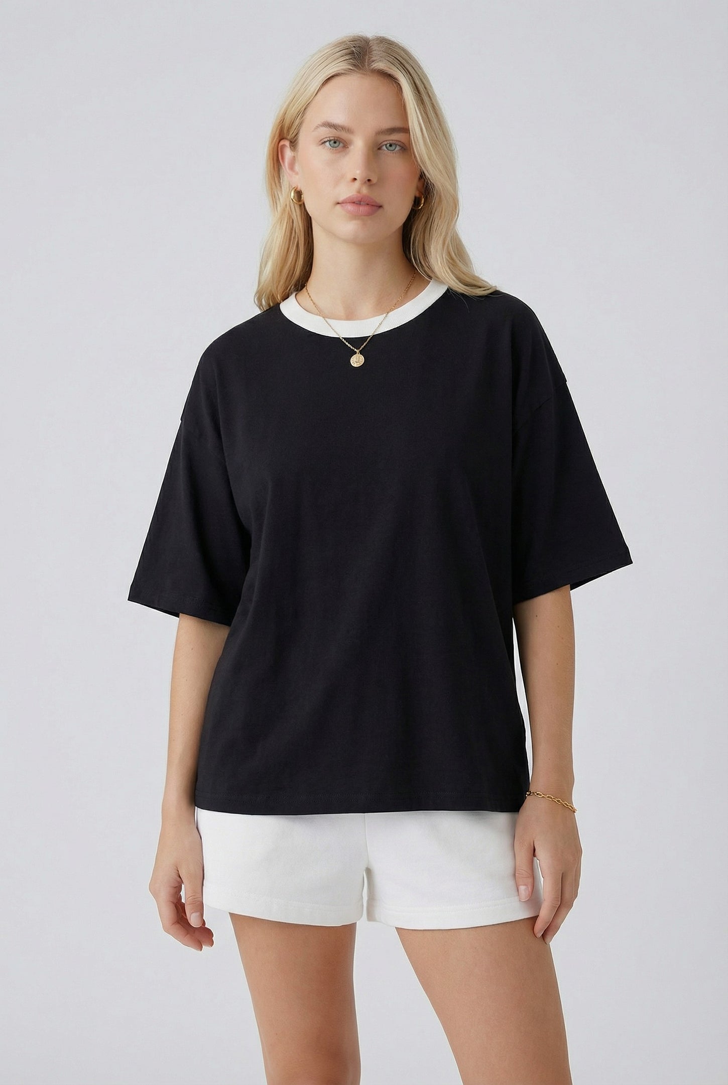 woman wearing a black oversized t-shirt with a white collar paired with white shorts
