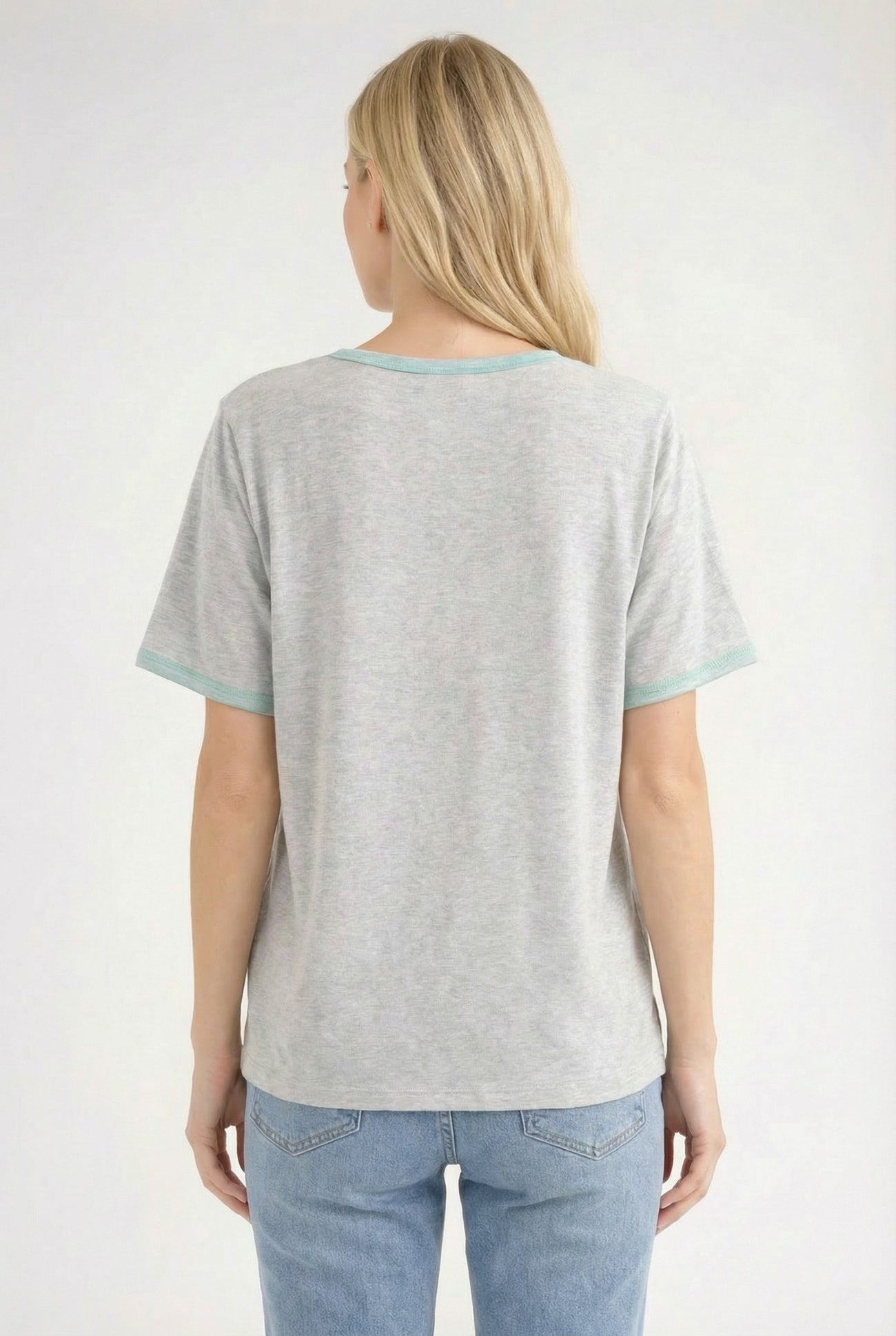 woman wearing a gray short sleeve t-shirt with teal trim and light blue jeans, viewed from the back