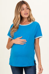 woman wearing a bright blue maternity t-shirt with contrasting trim and holding her baby bump
