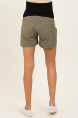 woman wearing olive green maternity shorts with a black waistband, viewed from the back