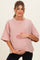 woman wearing a pink striped maternity top and holding her baby bump