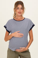 woman wearing a navy and white striped maternity top and holding her baby bump