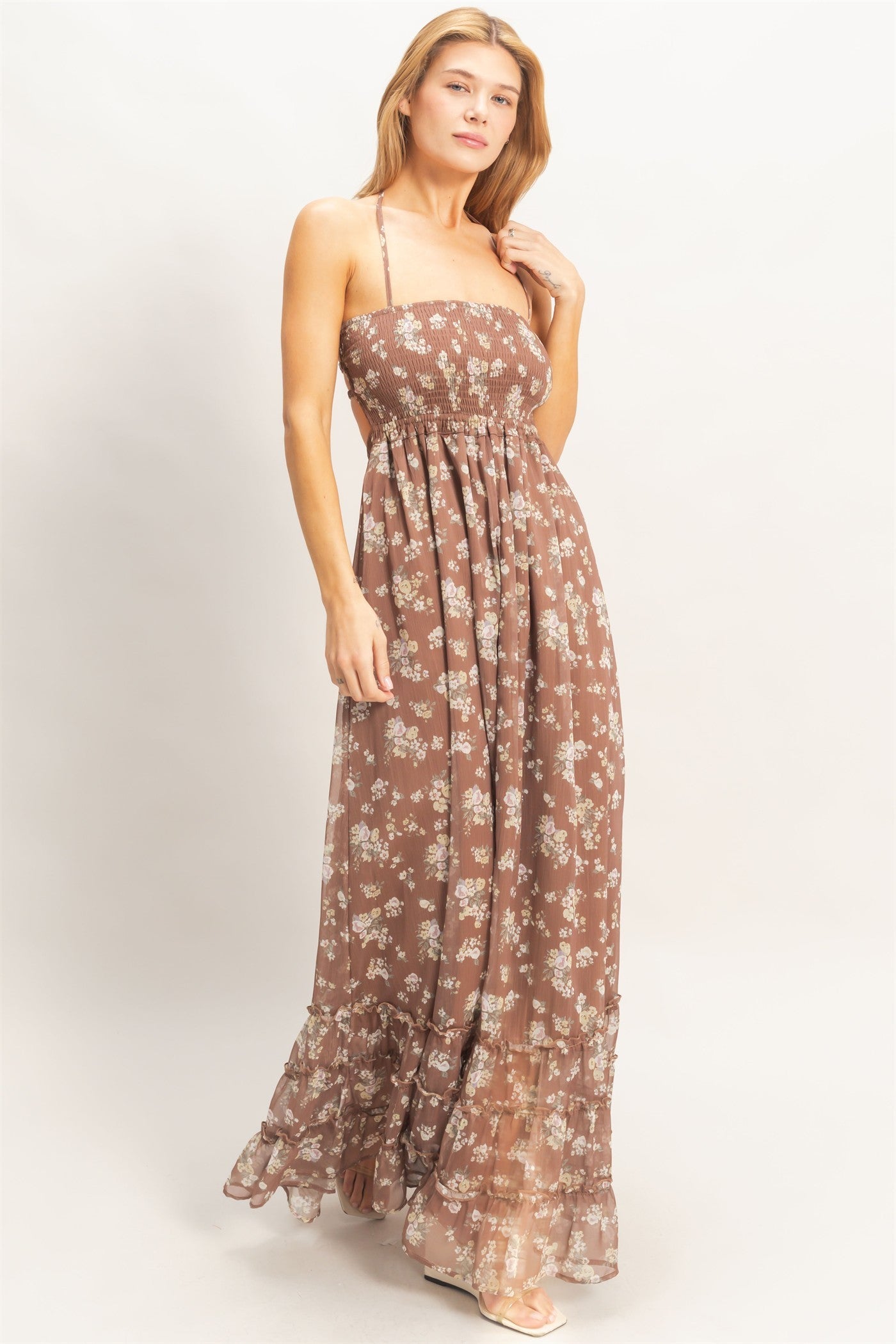 woman wearing a brown floral maxi dress with a smocked bodice and layered ruffle hem