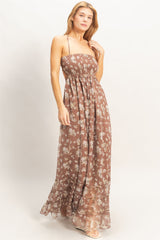 woman wearing a brown floral maxi dress with a smocked bodice and layered ruffle hem