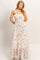 woman wearing a white floral maxi dress with a smocked bodice and adjustable straps