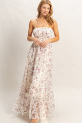 woman wearing a floral maxi dress with a smocked bodice and ruffled hem, styled with a natural makeup look