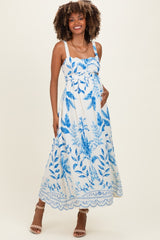 woman wearing a blue and white floral maternity maxi dress, showcasing her baby bump