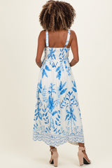 woman wearing a floral print maternity dress in white and blue, featuring a smocked back and adjustable straps
