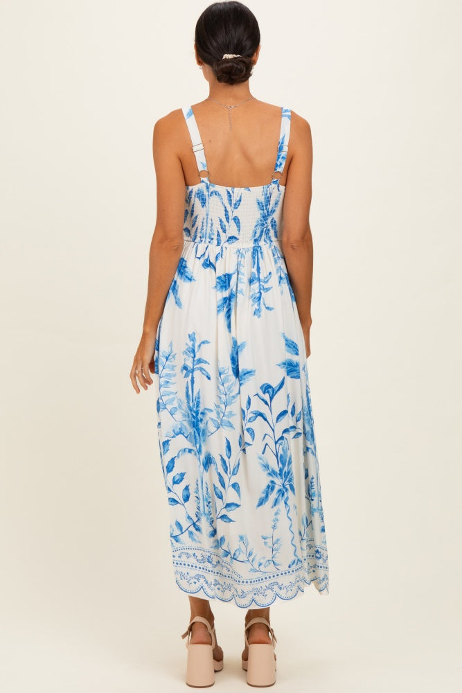 woman wearing a blue and white floral maxi dress with a smocked back and adjustable straps