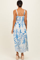 woman wearing a blue and white floral maxi dress with a smocked back and adjustable straps