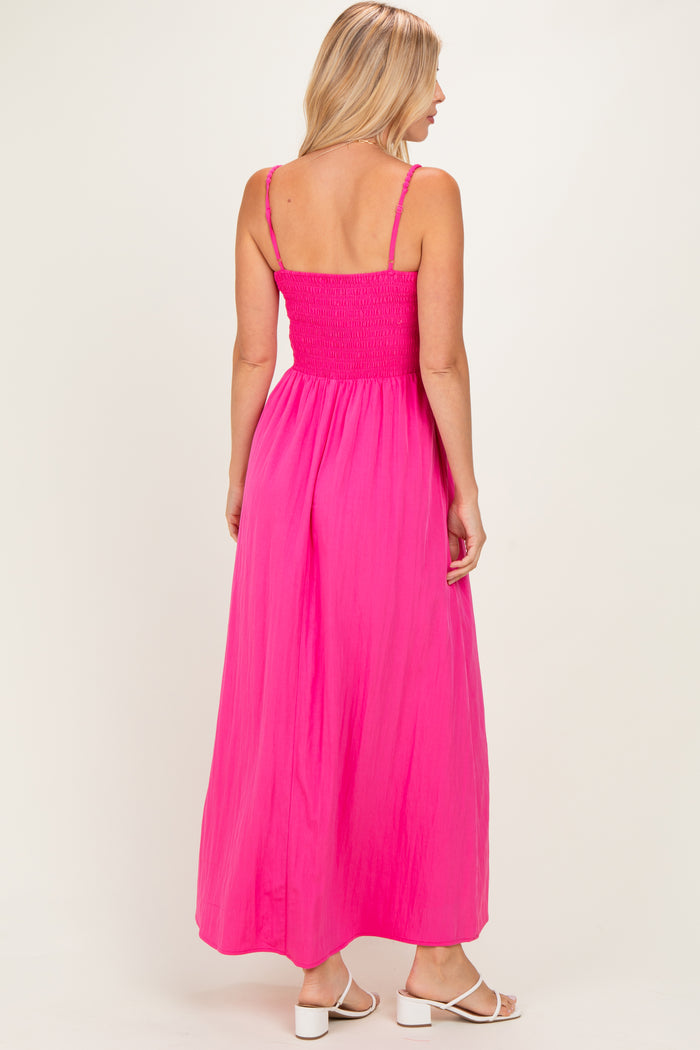 woman wearing a vibrant pink maxi dress with a smocked bodice and adjustable straps, viewed from the back