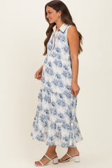 woman wearing a white floral maternity maxi dress with a collar and tiered design, showing her baby bump