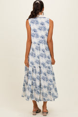 woman wearing a blue and white floral sleeveless maxi dress with a tiered skirt and back button detail