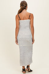 woman wearing a white and black striped maxi dress with thin straps, seen from the back