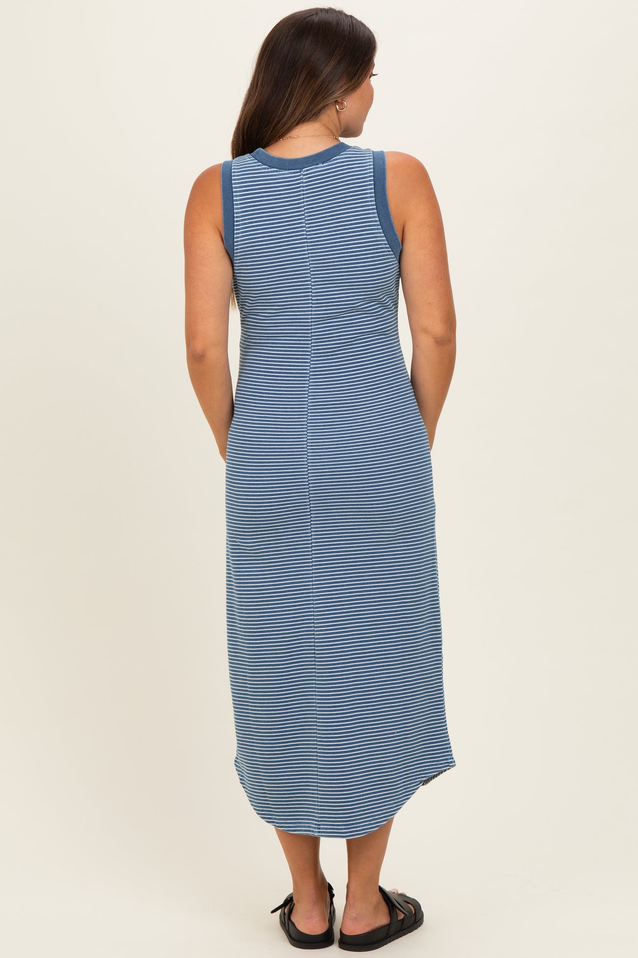 woman wearing a blue and white striped maternity maxi dress, showing the back view and styling with sandals