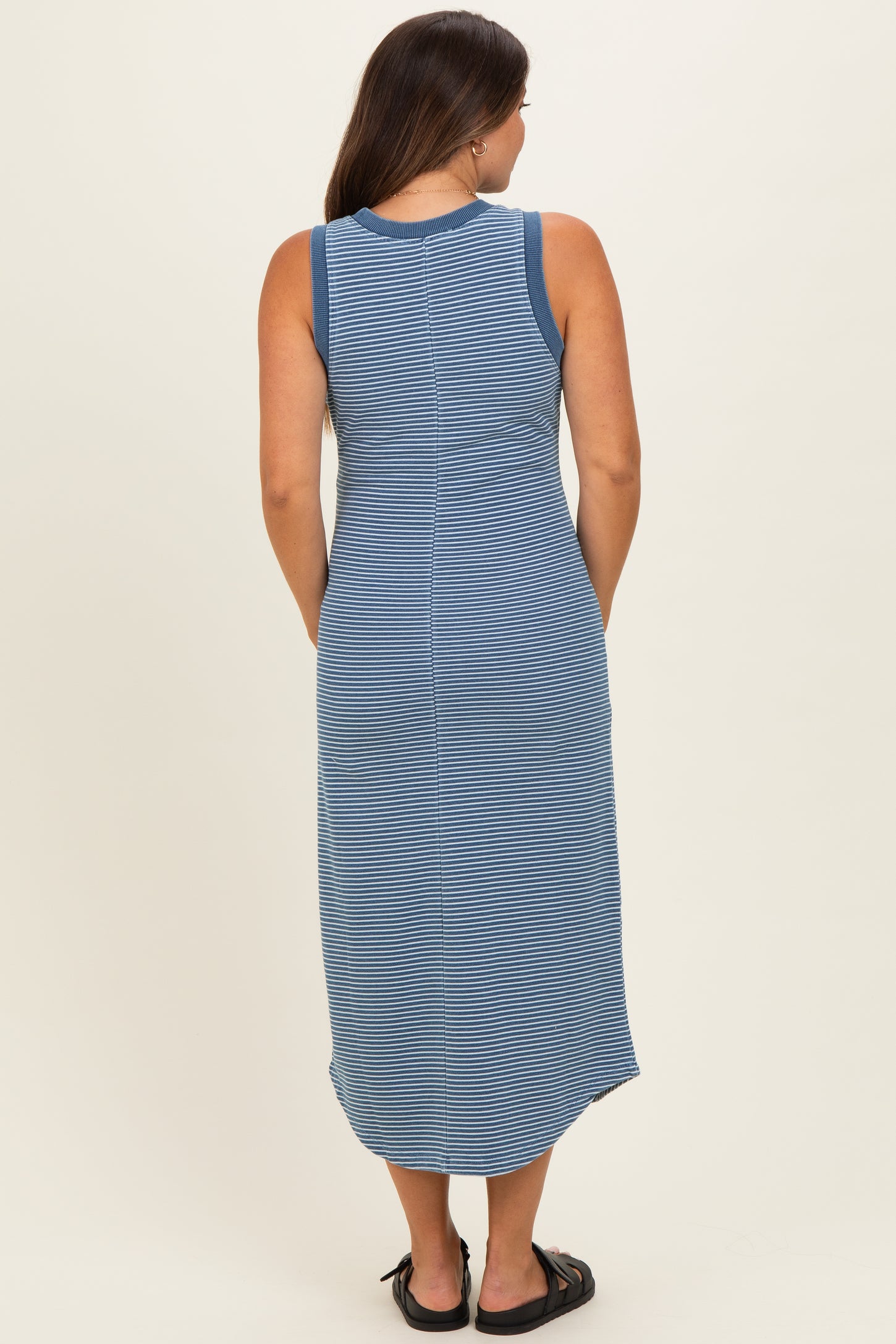 woman wearing a blue and white striped maternity maxi dress, showing the back view and styling with sandals
