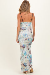 woman wearing a floral print maternity maxi dress with thin straps, showing a fitted silhouette and long flowy skirt