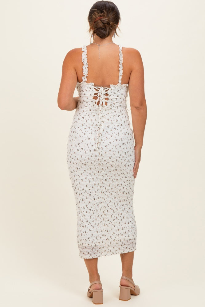 woman wearing a white floral print maternity midi dress with ruffle straps and lace-up back detail