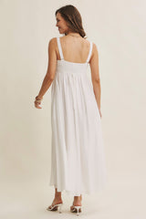 woman wearing a white maxi dress with a smocked back and thick straps, showing the back view