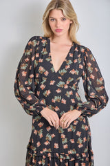 woman wearing a black floral long sleeve dress with a deep v-neck and tiered skirt