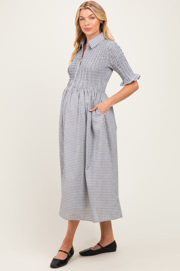 woman wearing a black and white checkered maternity dress with short sleeves and pockets, showcasing a baby bump