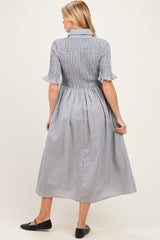 woman wearing a checkered midi maternity dress with short sleeves and a cinched waist from the back